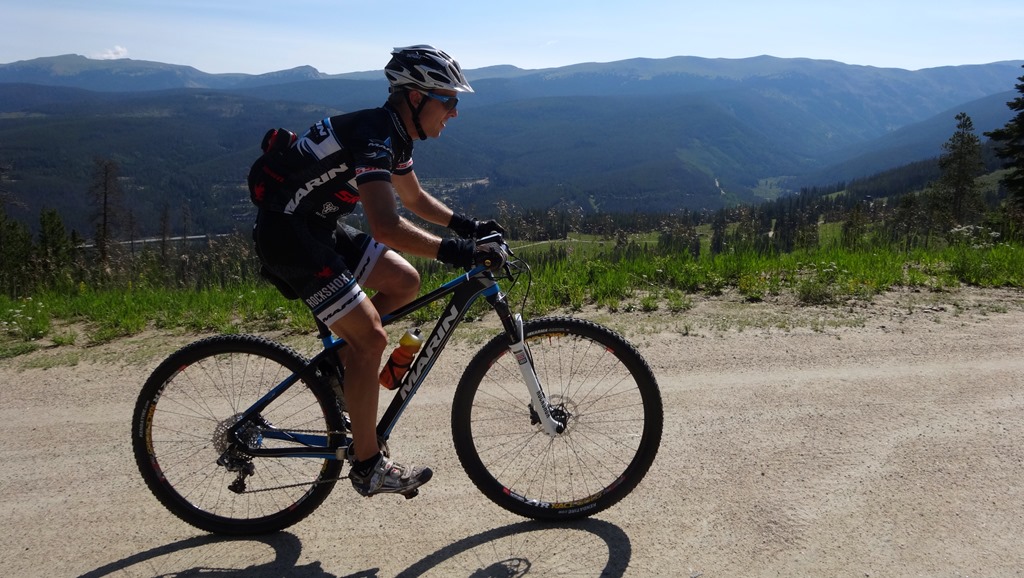 Bryan Alders climbing up through Winter Park ski area on the way to preride the XC course